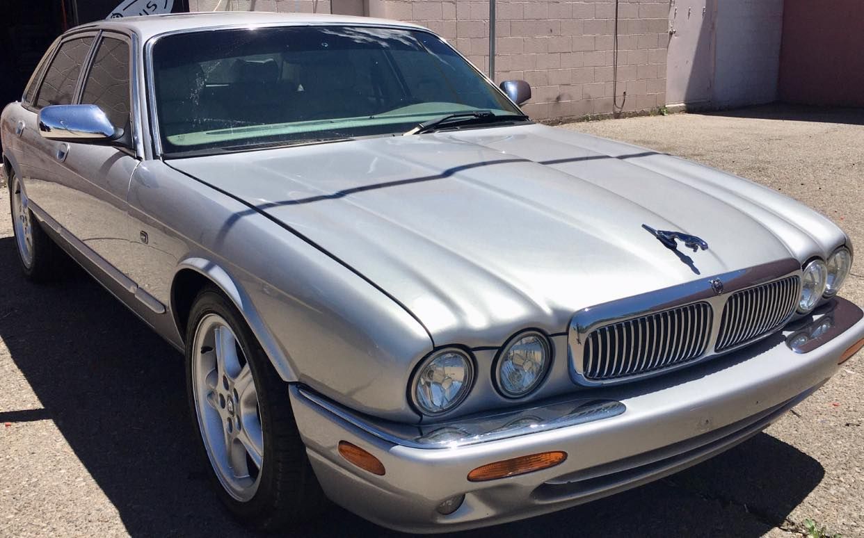 Silver Jaguar sedan parked outdoors.
