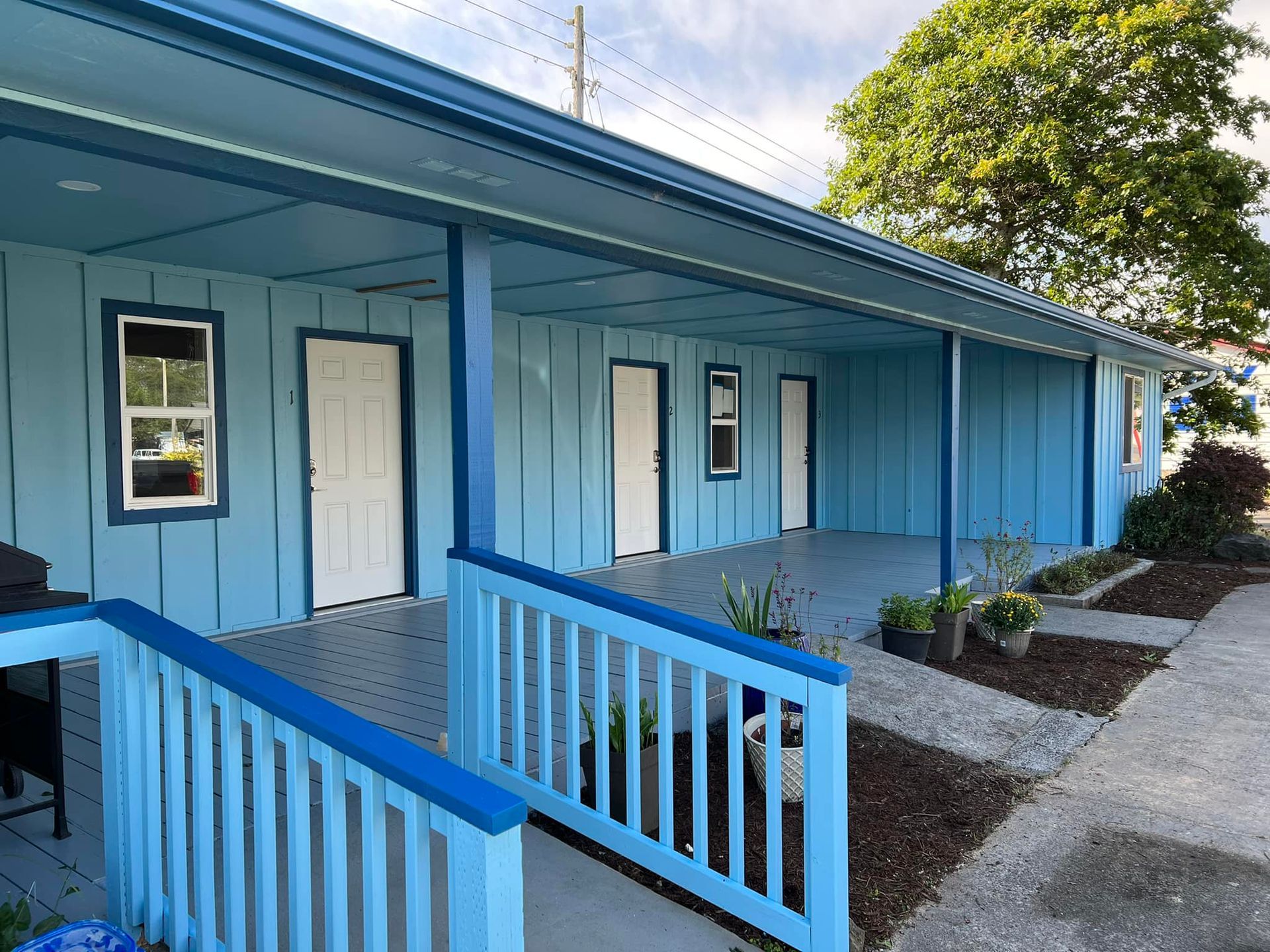 A blue building with white doors and a blue railing