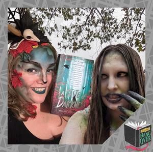 Two women are standing next to each other holding a book.
