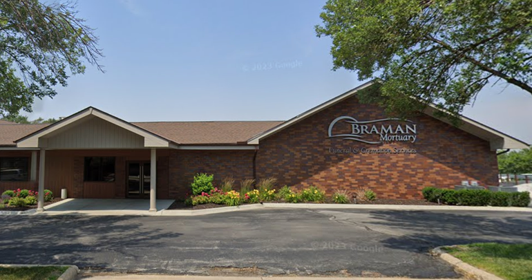 Brick church building with sign reading “Braman,” fronted by a covered entrance and parking lot