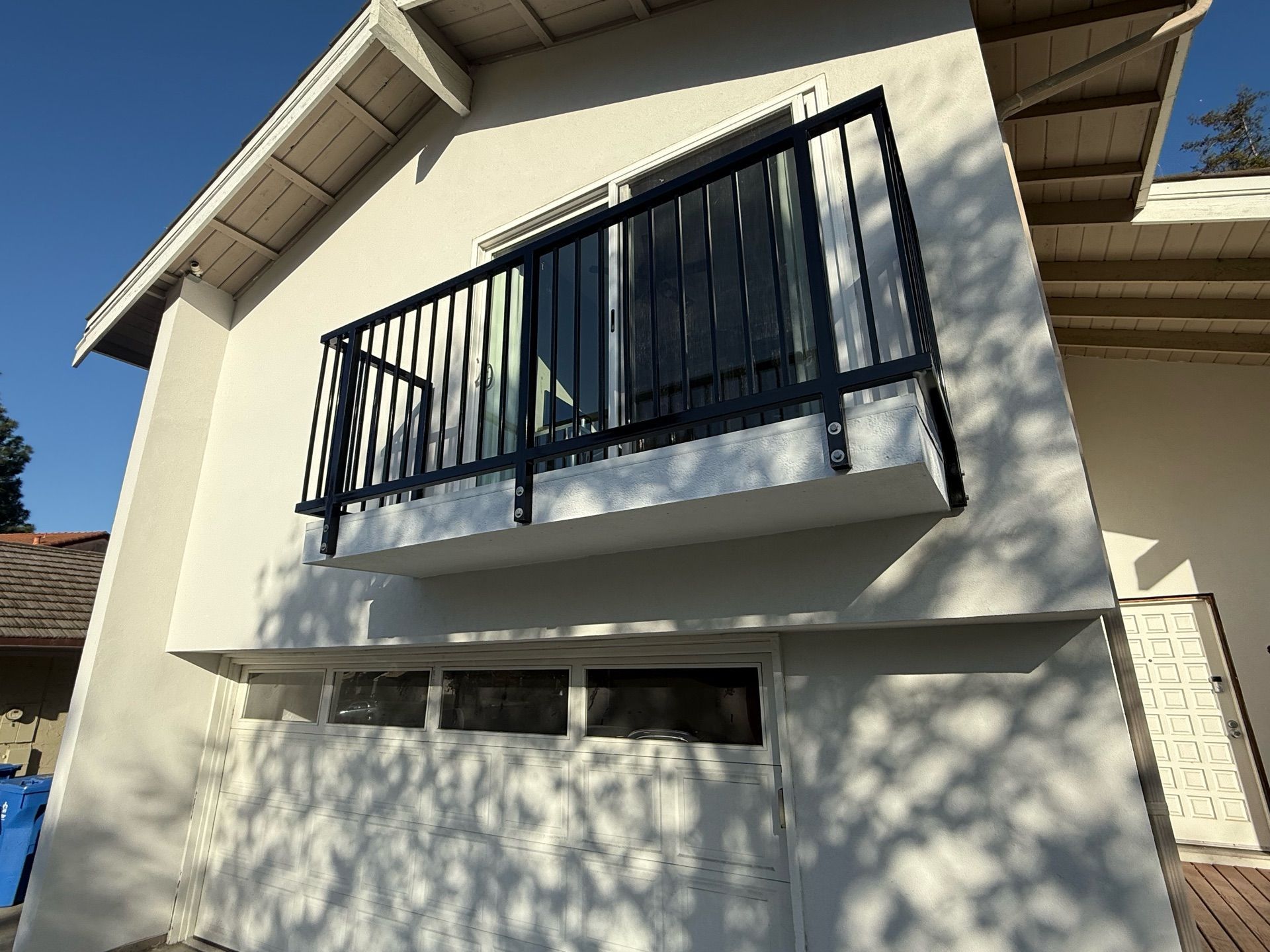 A white house with a balcony on the side of it