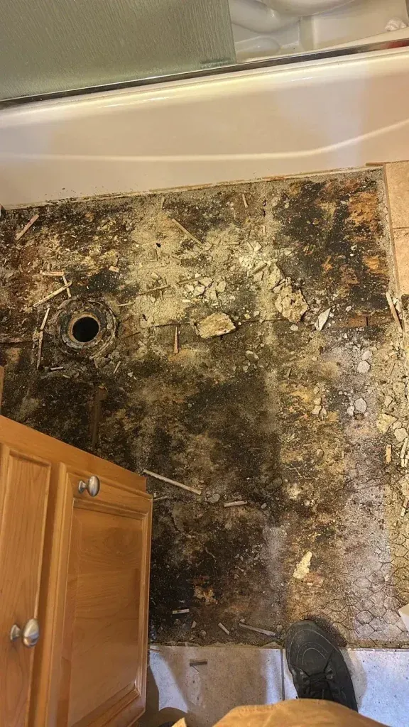 A bathroom with a dirty wall and cabinets.