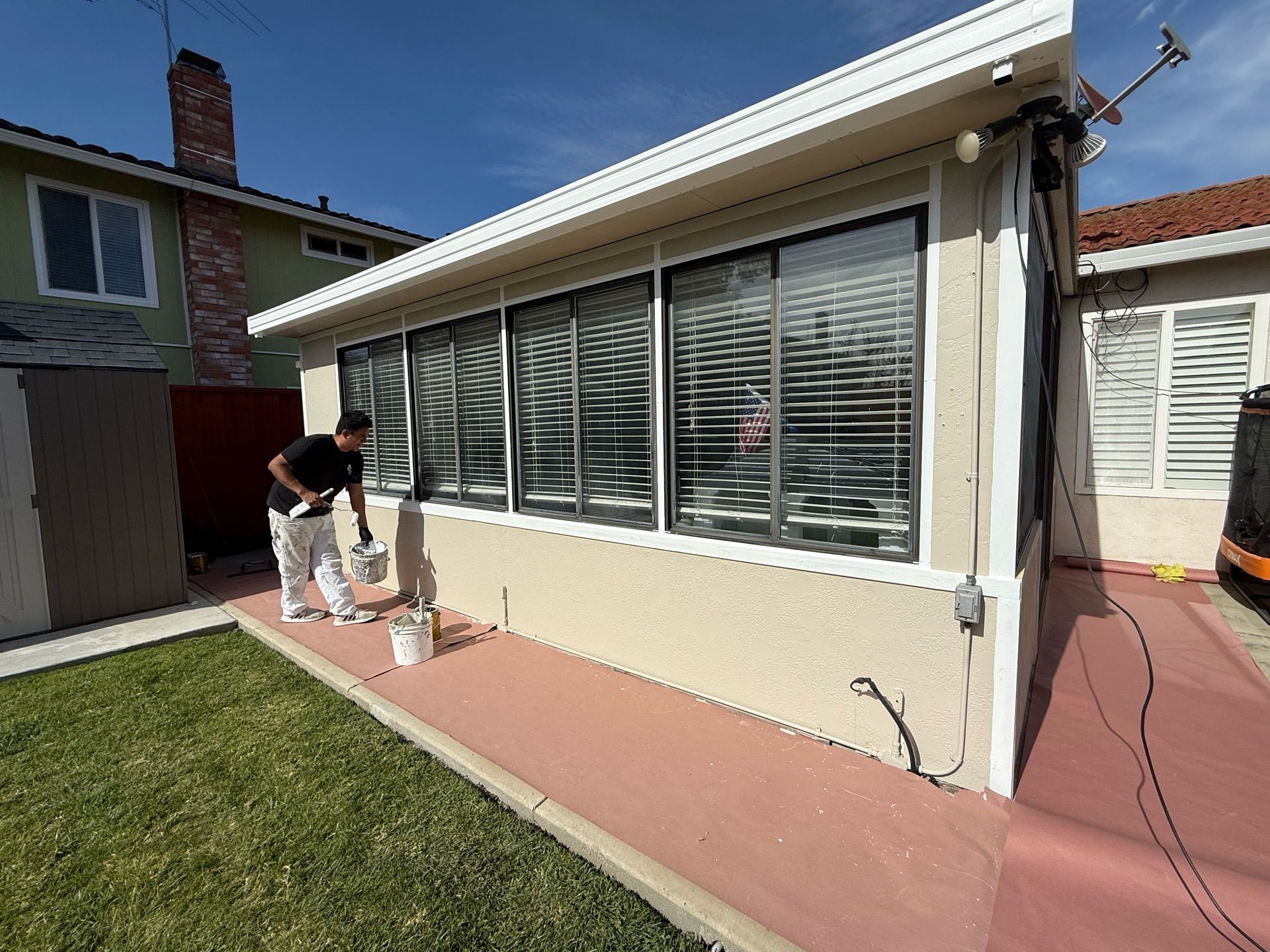 A man is painting the side of a house.