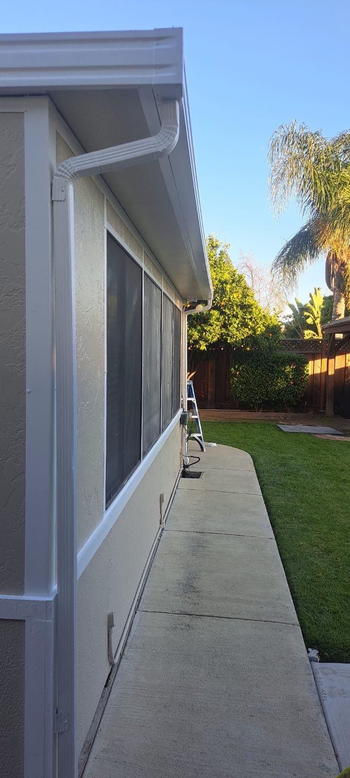 A side view of a house with a gutter on the side of it.