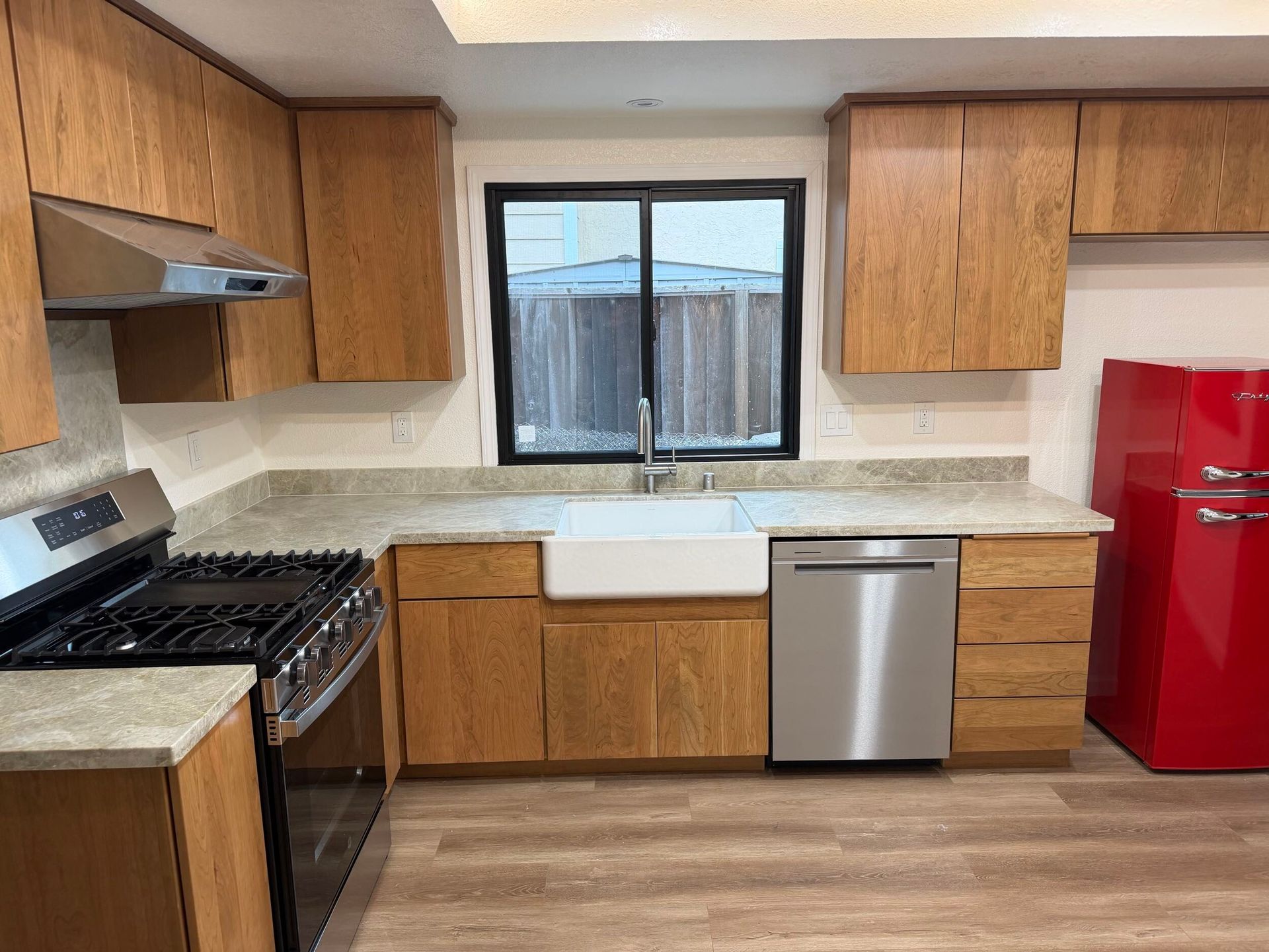 Modern kitchen remodel featuring new wood cabinetry, updated countertops, farmhouse sink, stainless steel appliances, and improved lighting. Full kitchen renovation showcasing before and after transformation, optimized layout, durable flooring, and contemporary finishes designed for functionality, comfort, and style in a residential home renovation project.