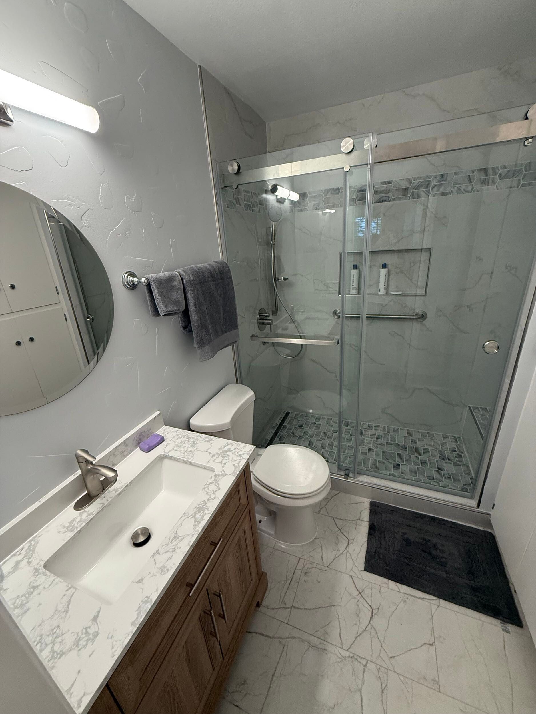 Dream Build Services delivered a full bathroom renovation in the Bay Area, upgrading an outdated bath into a sophisticated modern retreat. The project included new tile installation with marble patterns, a custom walk-in shower with glass doors and chrome fixtures, updated vanity cabinetry, and improved lighting for a brighter, more inviting space. This remodel combines functionality with elegant design, reflecting Dream Build Services’ commitment to quality craftsmanship and comfort.