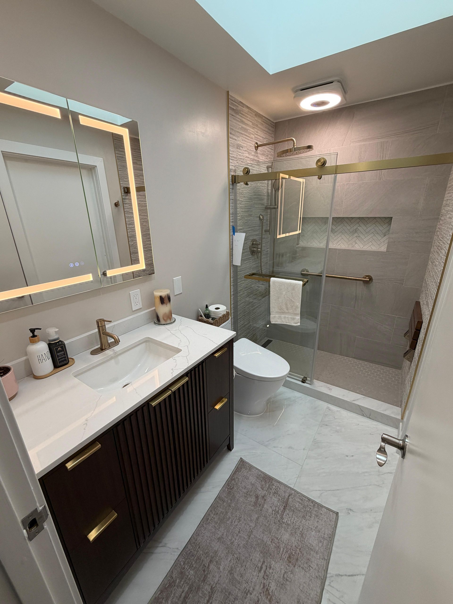 Complete bathroom remodeling transformation featuring a modern walk-in shower with frameless glass enclosure, large-format porcelain wall tile, custom shower niche, luxury rainfall shower system, floating-style vanity with quartz countertop, LED medicine cabinet, brushed gold fixtures, premium porcelain flooring, contemporary lighting, and upgraded plumbing fixtures. This full bathroom renovation replaced an outdated bathtub with a spacious walk-in shower, maximizing functionality, accessibility, and modern design while increasing home value.
Dream Build Services specializes in custom bathroom remodeling, bathroom renovations, shower conversions, tub-to-shower replacements, vanity installations, tile installation, flooring, lighting upgrades, plumbing fixtures, and complete home remodeling throughout the San Francisco Bay Area.