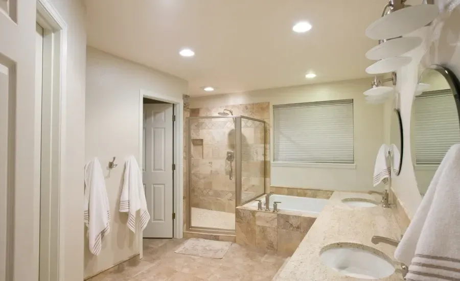 A bathroom with two sinks , a tub , and a walk in shower.