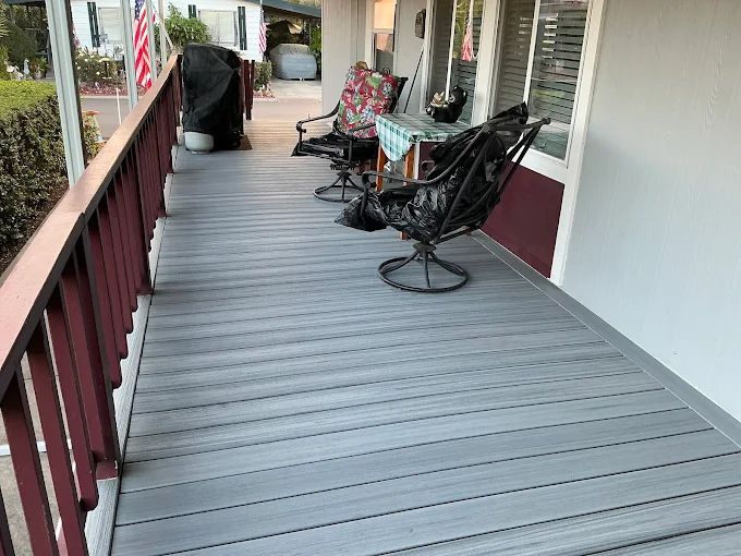 Composite deck remodel featuring gray low-maintenance decking boards, upgraded stair system with integrated step lighting, refreshed porch surface, and improved outdoor living functionality. Exterior renovation completed by Dream Build Services, specializing in deck replacement, composite decking installation, porch remodeling, and residential exterior upgrades in the Bay Area.