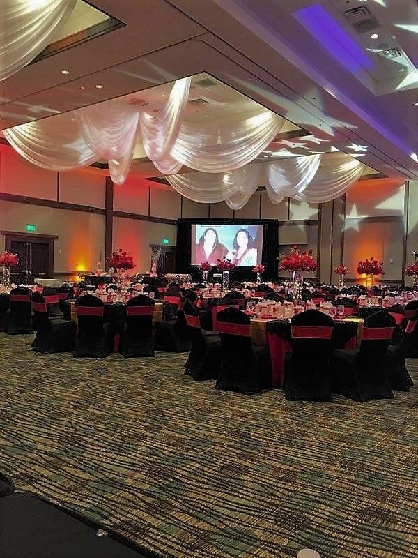 A large room with tables and chairs set up for a wedding reception