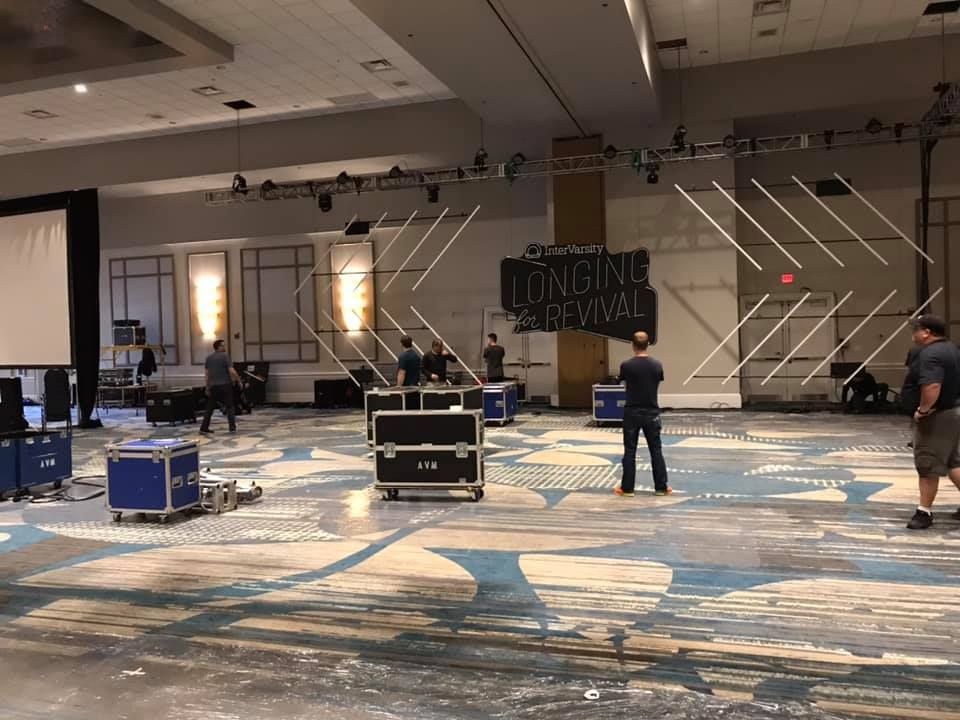 A group of people are standing in a large room.