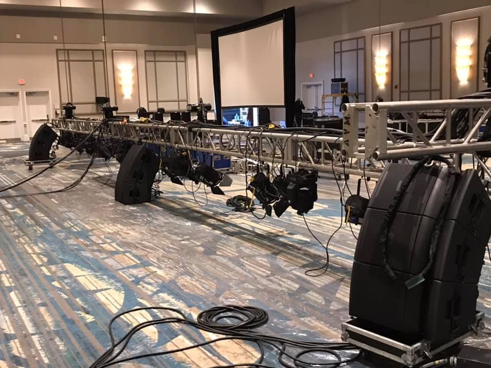 A large room with a lot of speakers and a projector screen.