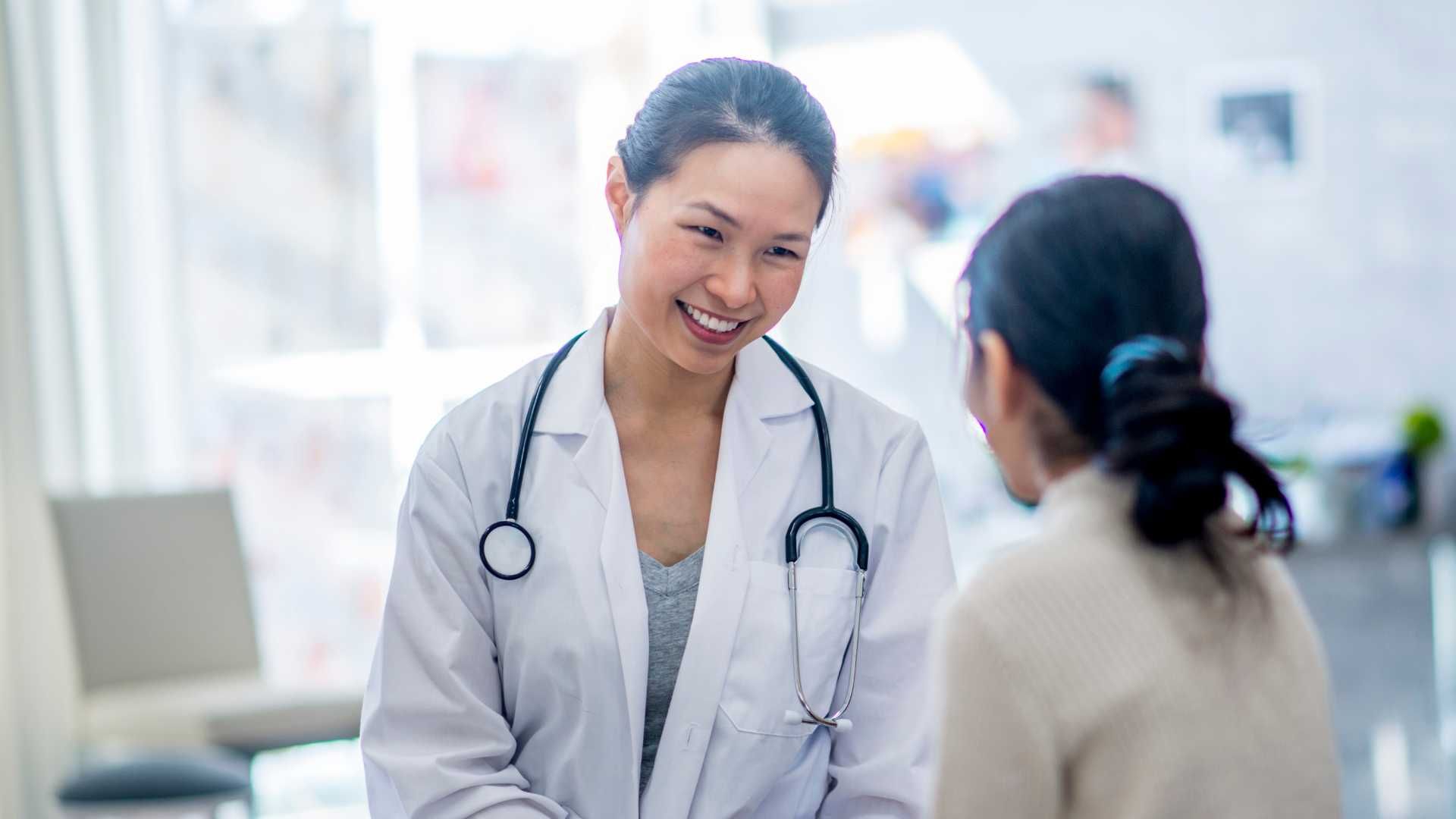 A female doctor is talking to a patient in a hospital.