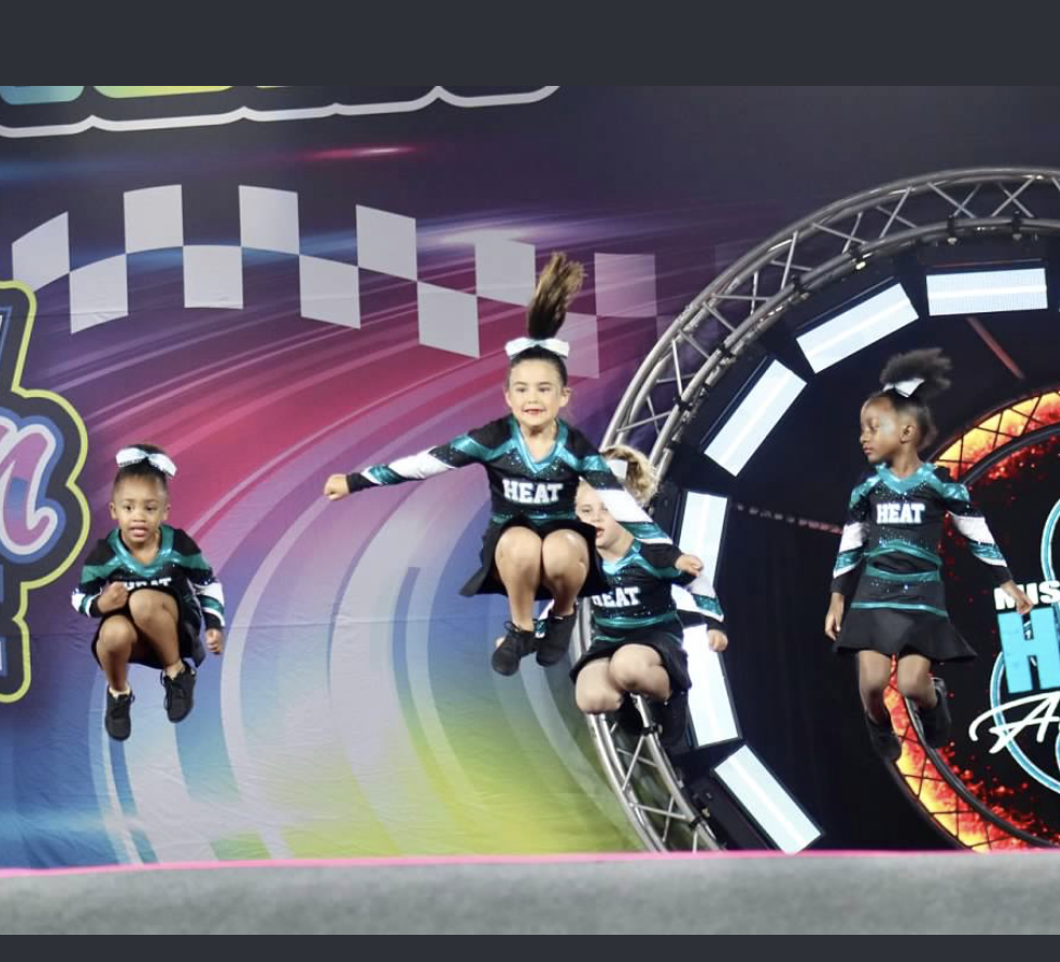 Cheerleaders wearing heat uniforms are jumping in the air