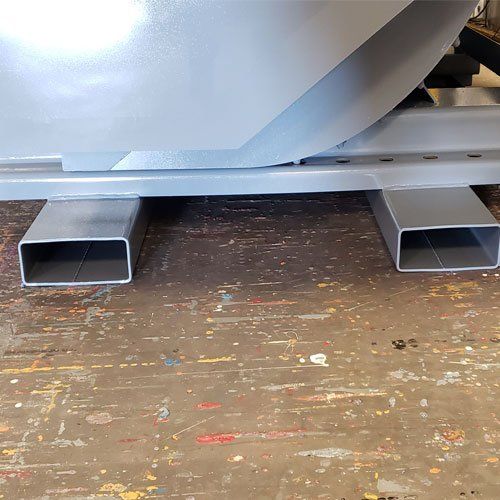 Gray rectangular metal supports under a larger industrial structure.