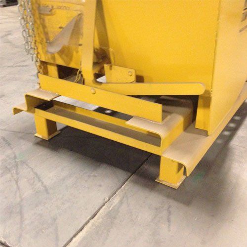 Yellow industrial container on a concrete floor, featuring a support structure and locking mechanism.