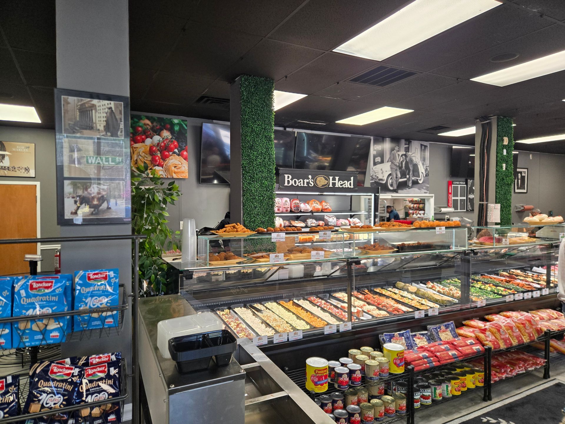 Supermarket deli display with pastries, snacks, and bright overhead lighting