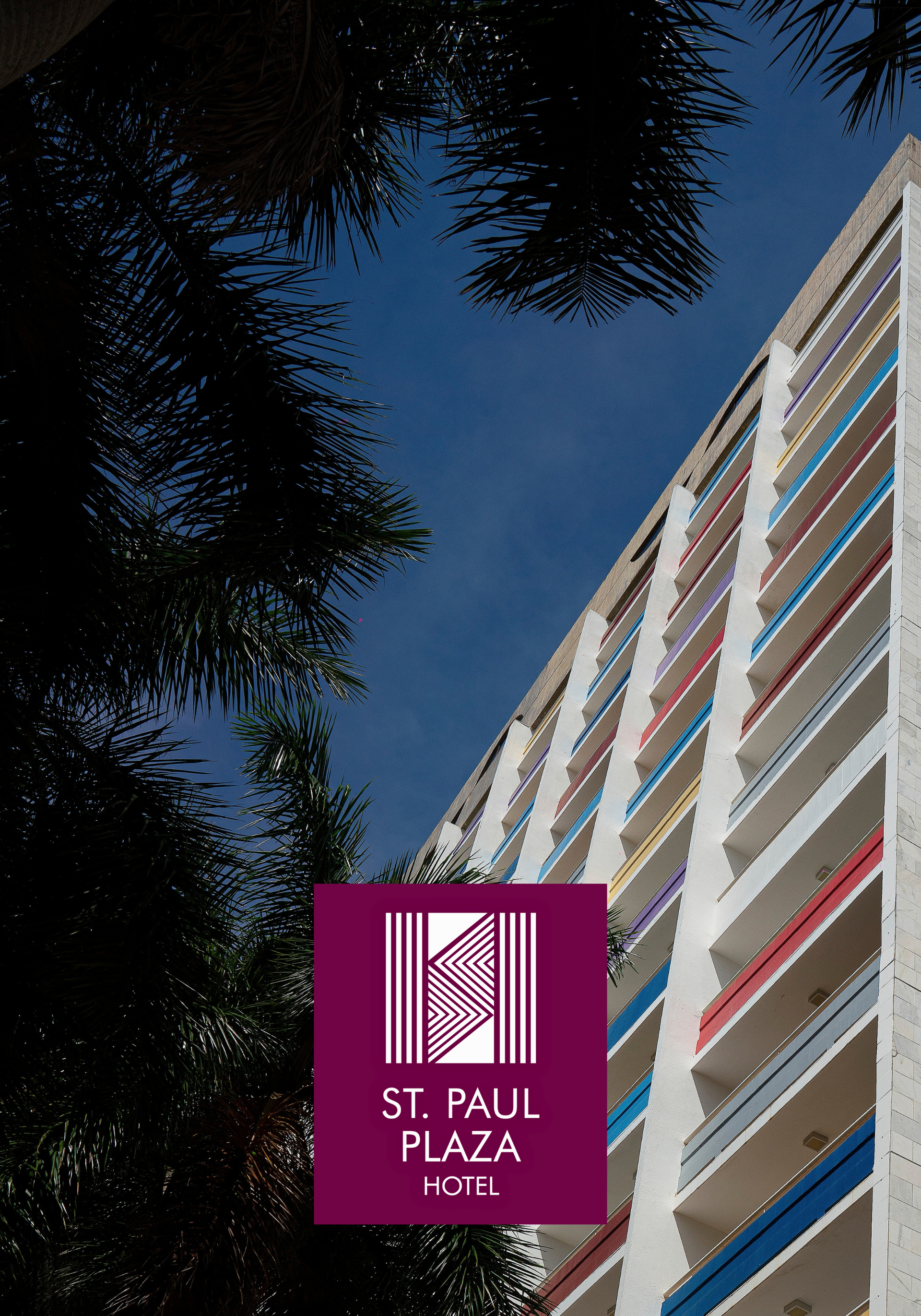 Exterior do St. Paul Plaza Hotel com varandas coloridas. Logotipo na frente.