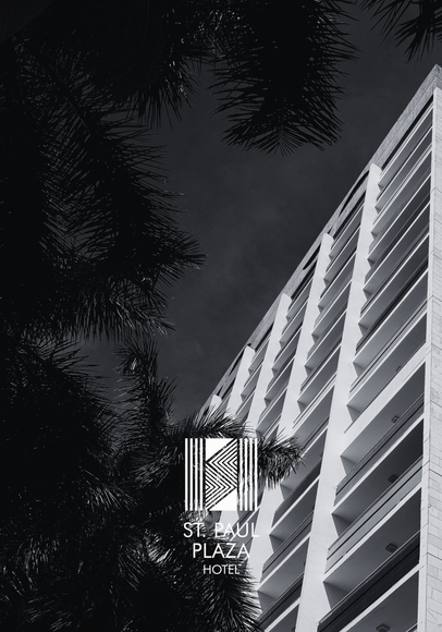 St. Paul Plaza Hotel, um edifício alto de concreto com varandas, logotipo e palmeira.