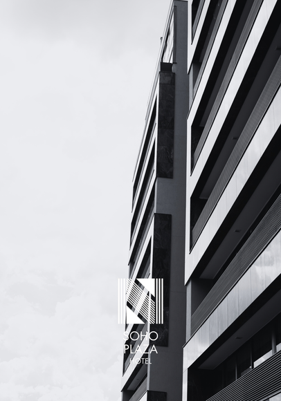 Vista em preto e branco de um edifício de hotel de vários andares com varandas com vista para uma piscina, apresentando o logotipo do Soho Plaza.