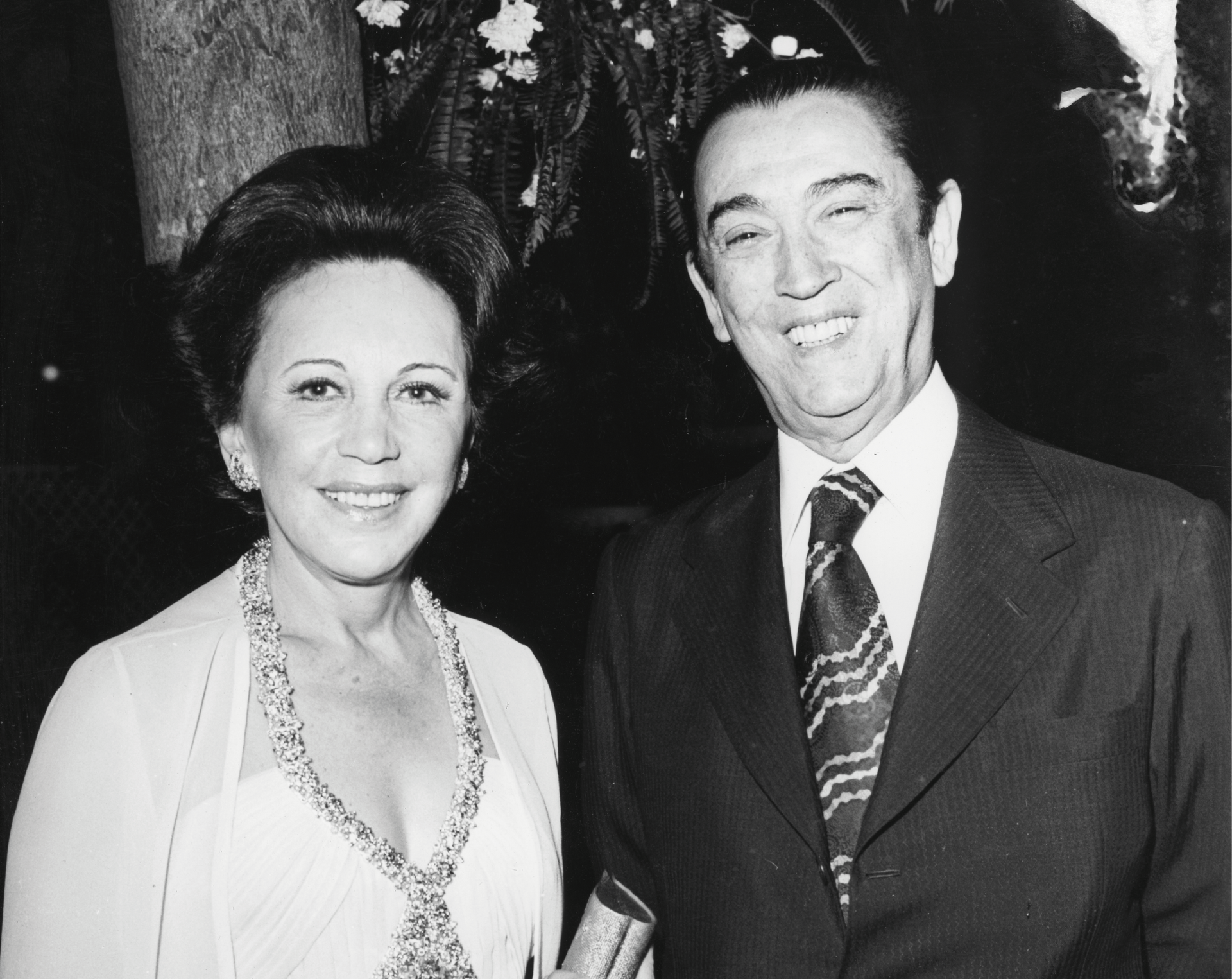 Um retrato em preto e branco de Celia Cruz e Pedro Knight posando juntos, ambos sorrindo para a câmera.