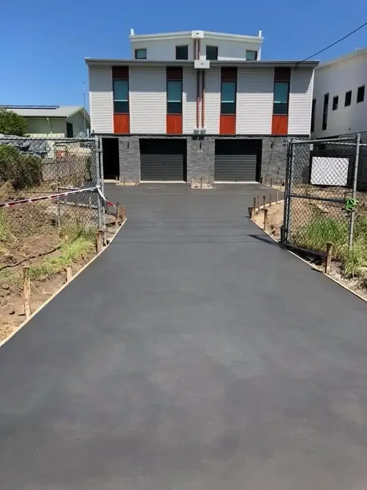 A Concrete Driveway Leading To A House With Two Garages — Luke Seears Concreting in Port Macquarie, NSW
