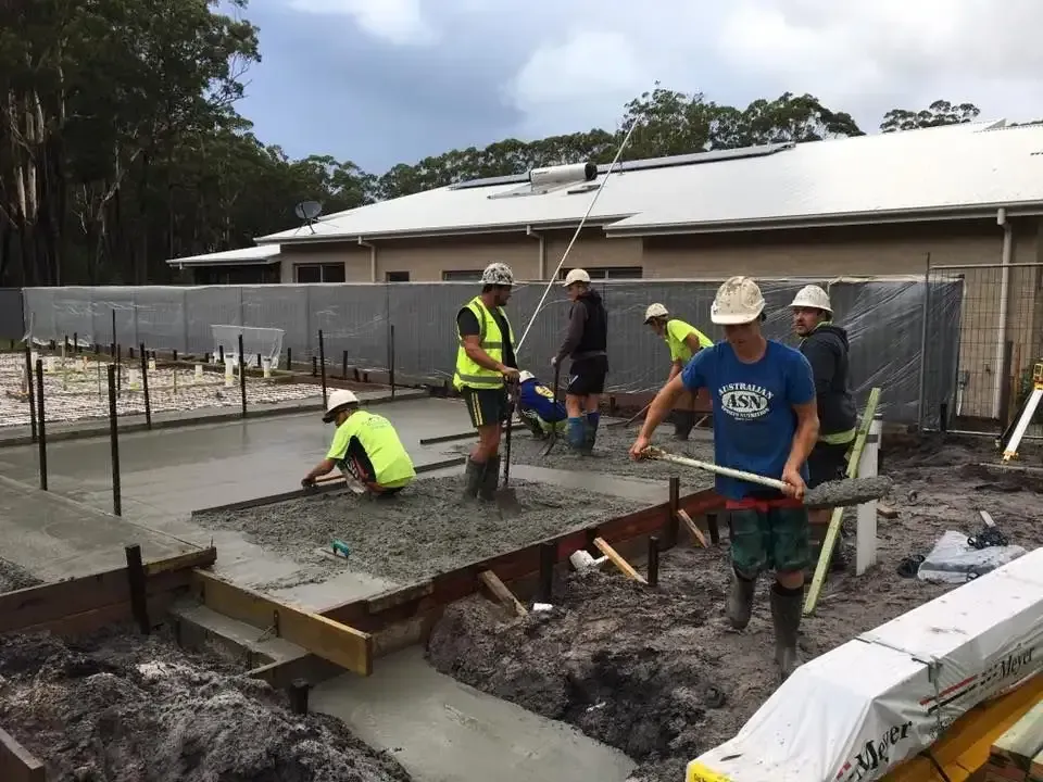A Group Of Construction Workers Are Working On A Concrete Base — Luke Seears Concreting in Port Macquarie, NSW