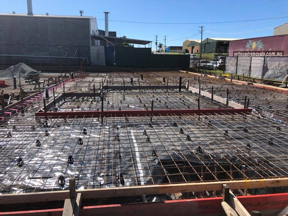 A Construction Site With A Building In The Background — Luke Seears Concreting in Port Macquarie, NSW