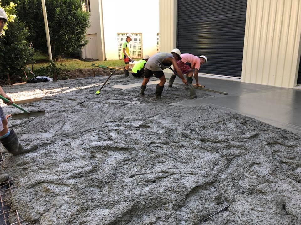 A Group Of Men Are Working On A Concrete Driveway — Luke Seears Concreting in Laurieton, NSW