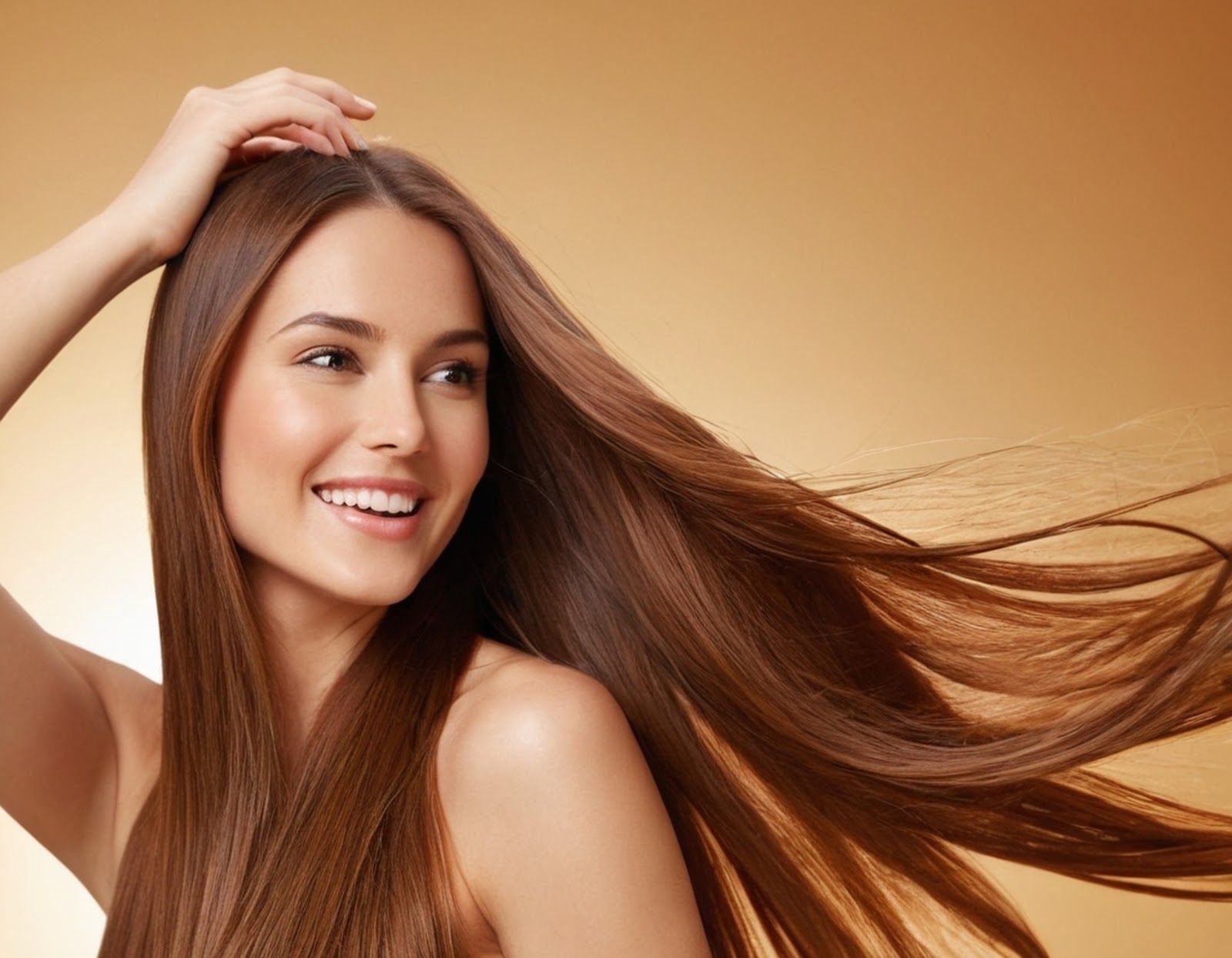 Smiling woman with long brown hair flowing against a warm beige background