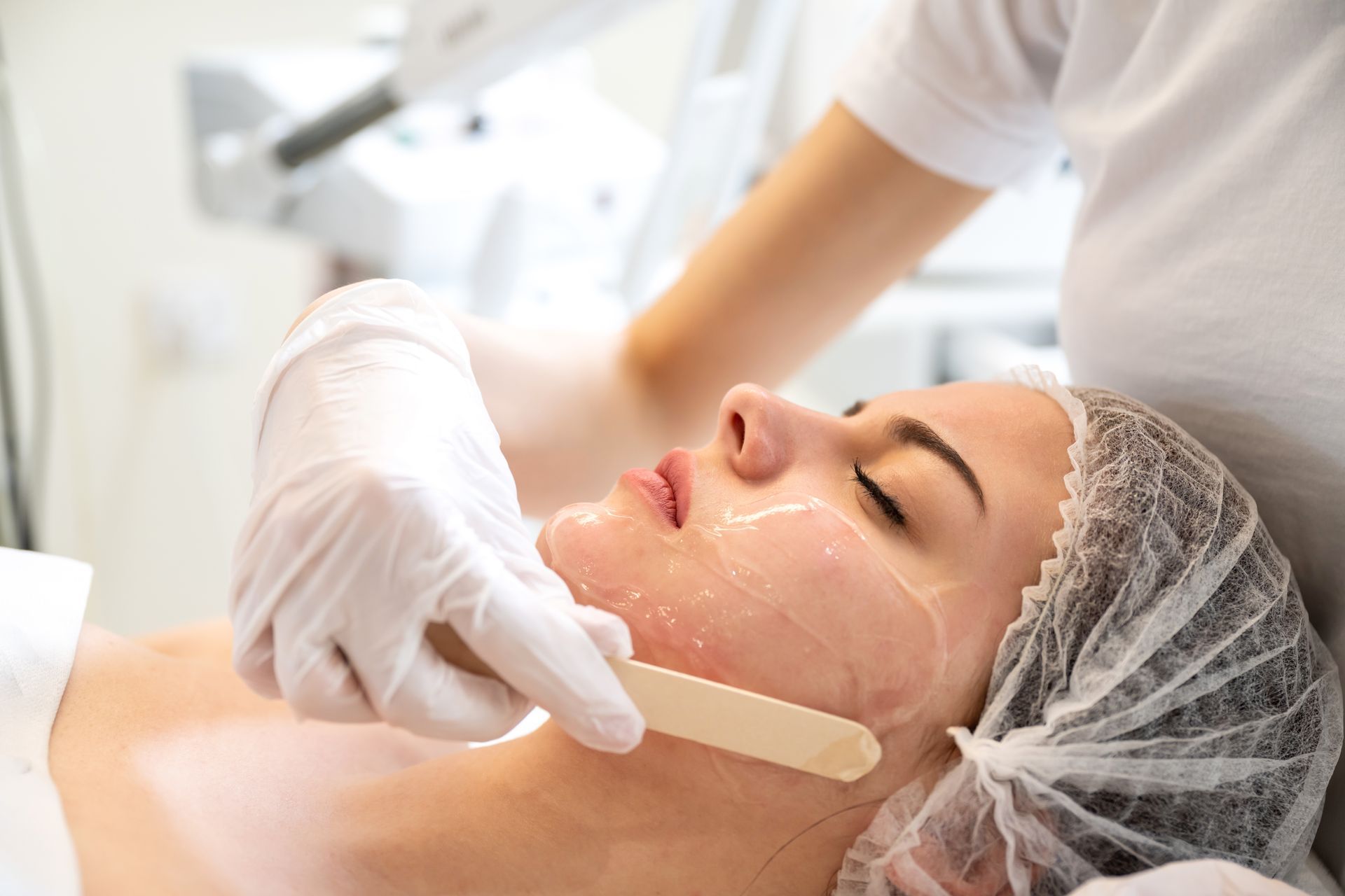 A woman is getting a facial treatment at a beauty salon.