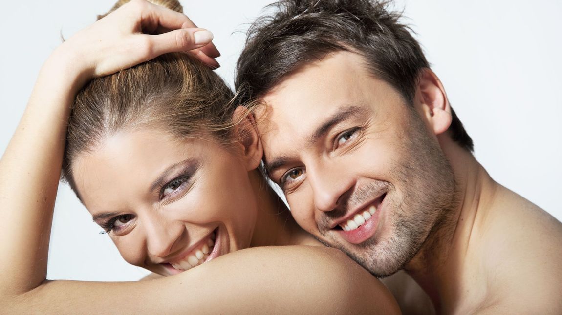 A man and a woman are looking at each other and smiling.