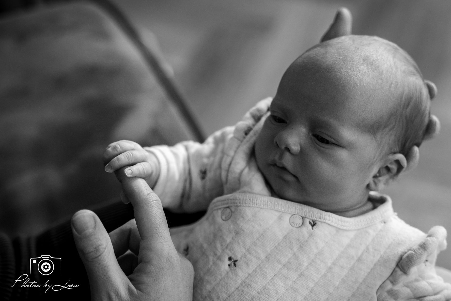 Een zwart-witfoto van een persoon die een baby vasthoudt.