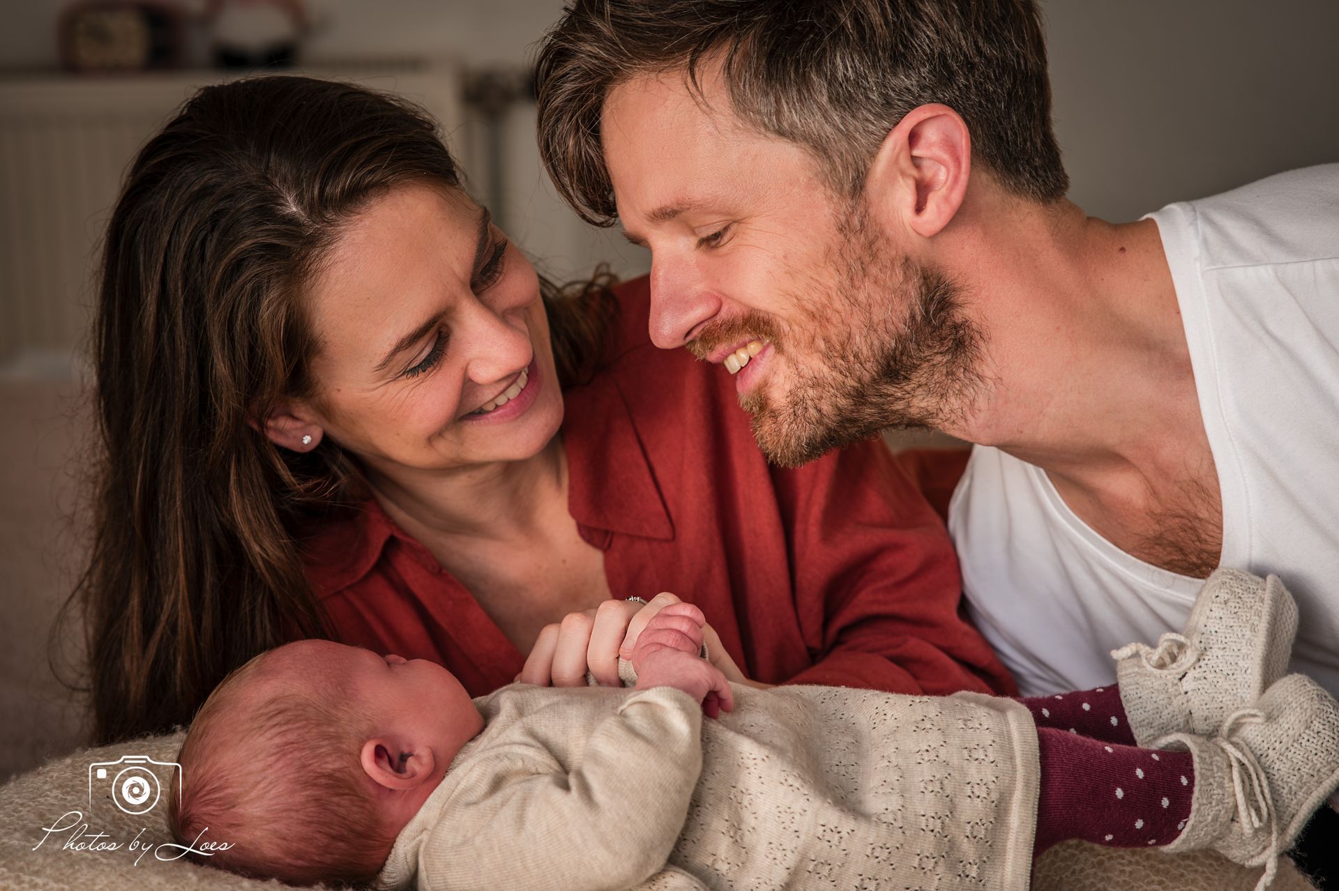 Een man en een vrouw houden een pasgeboren baby vast.