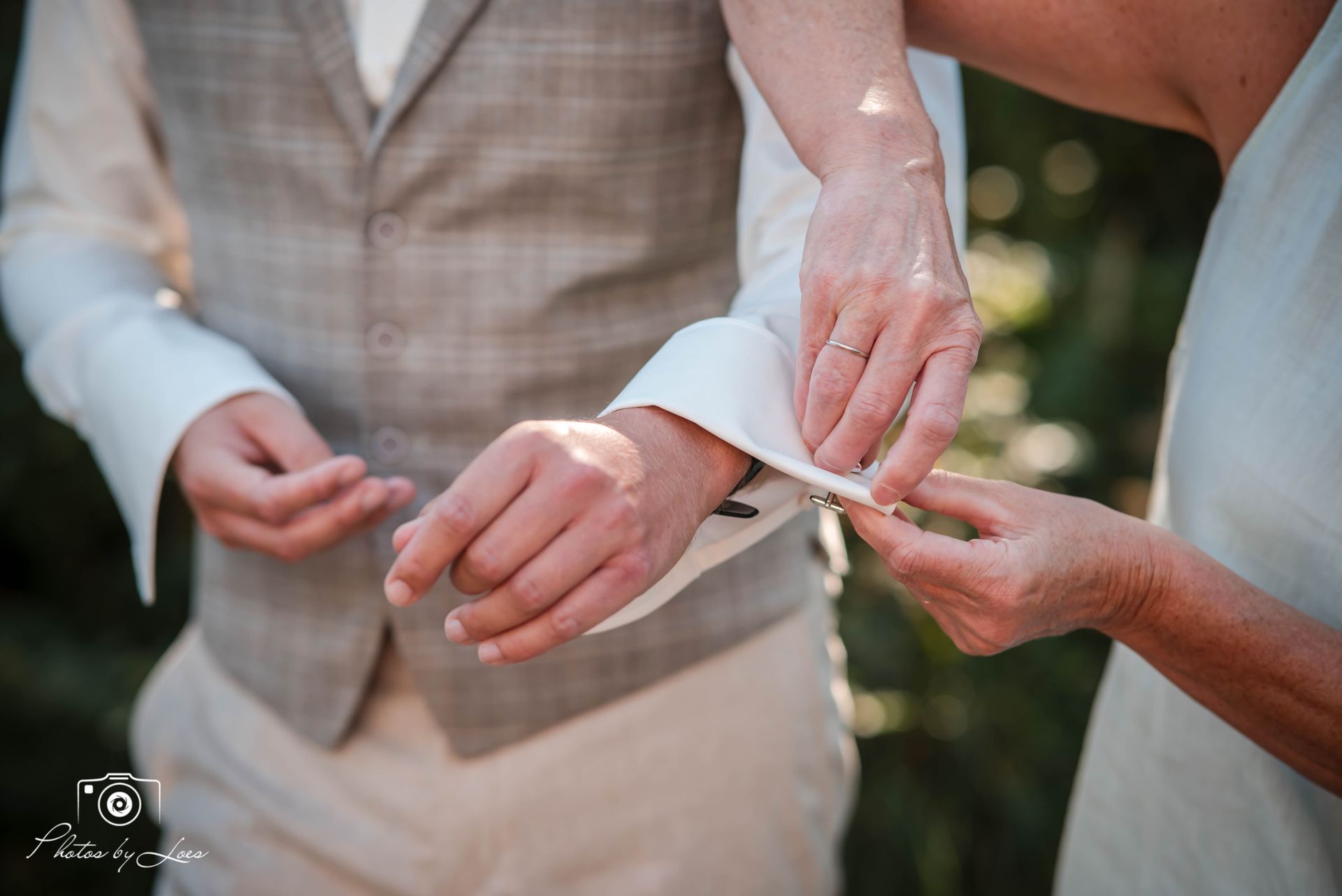 Een vrouw schuift een trouwring om de pols van een man.