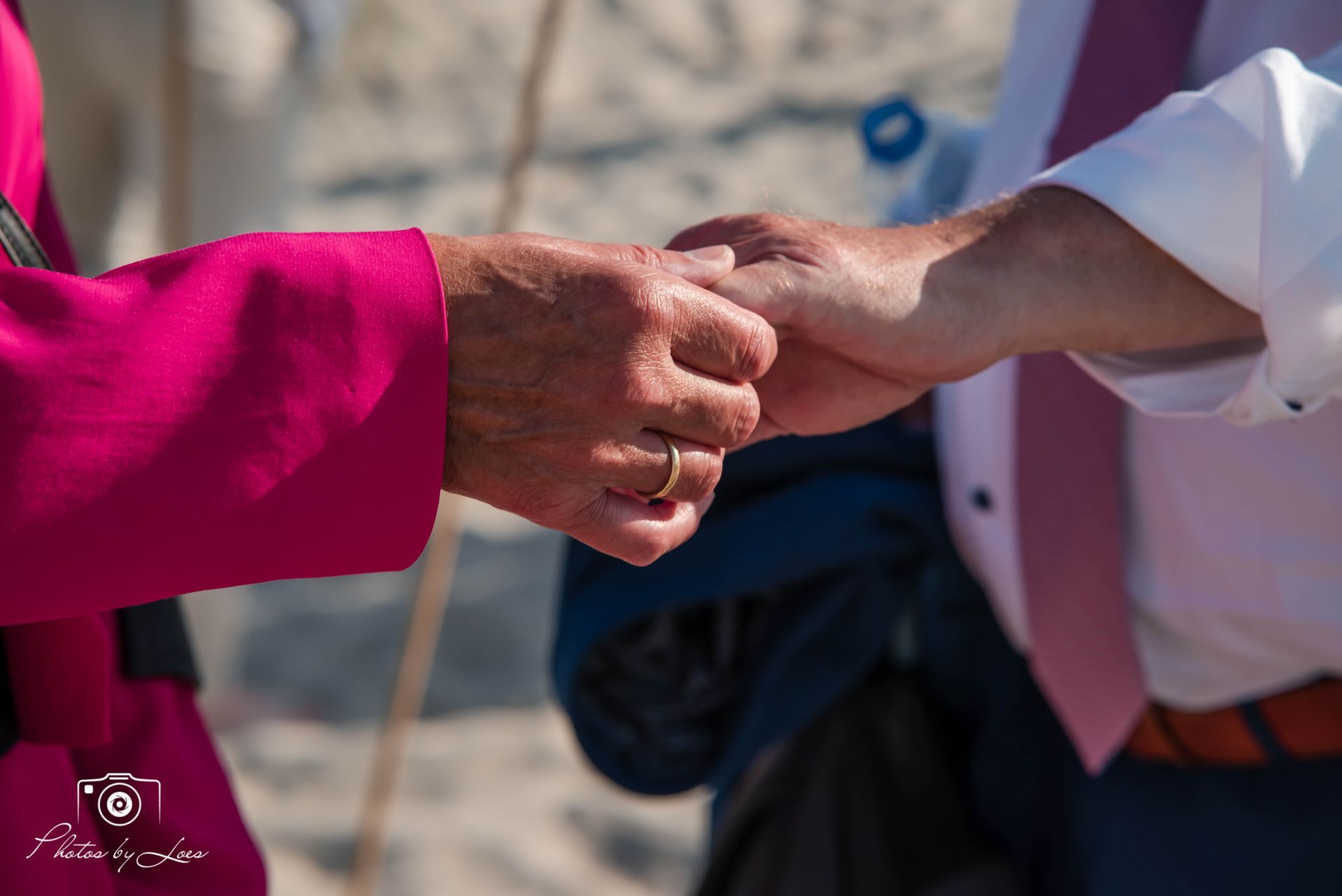 Een vrouw schuift een trouwring om de vinger van een man.