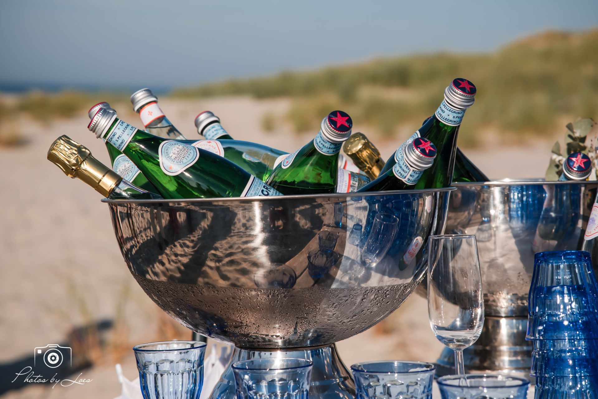 Een schaal gevuld met flessen wijn en champagne op een tafel.