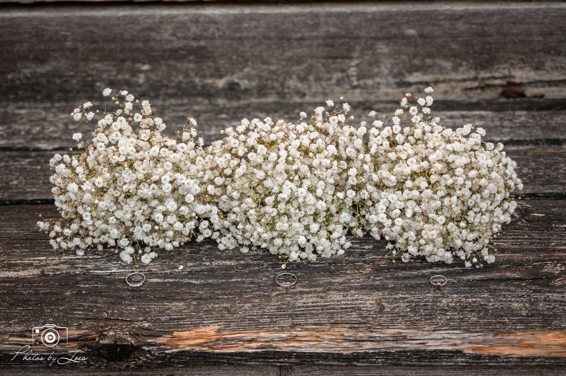 Een bosje gipskruidbloemen ligt op een houten tafel.