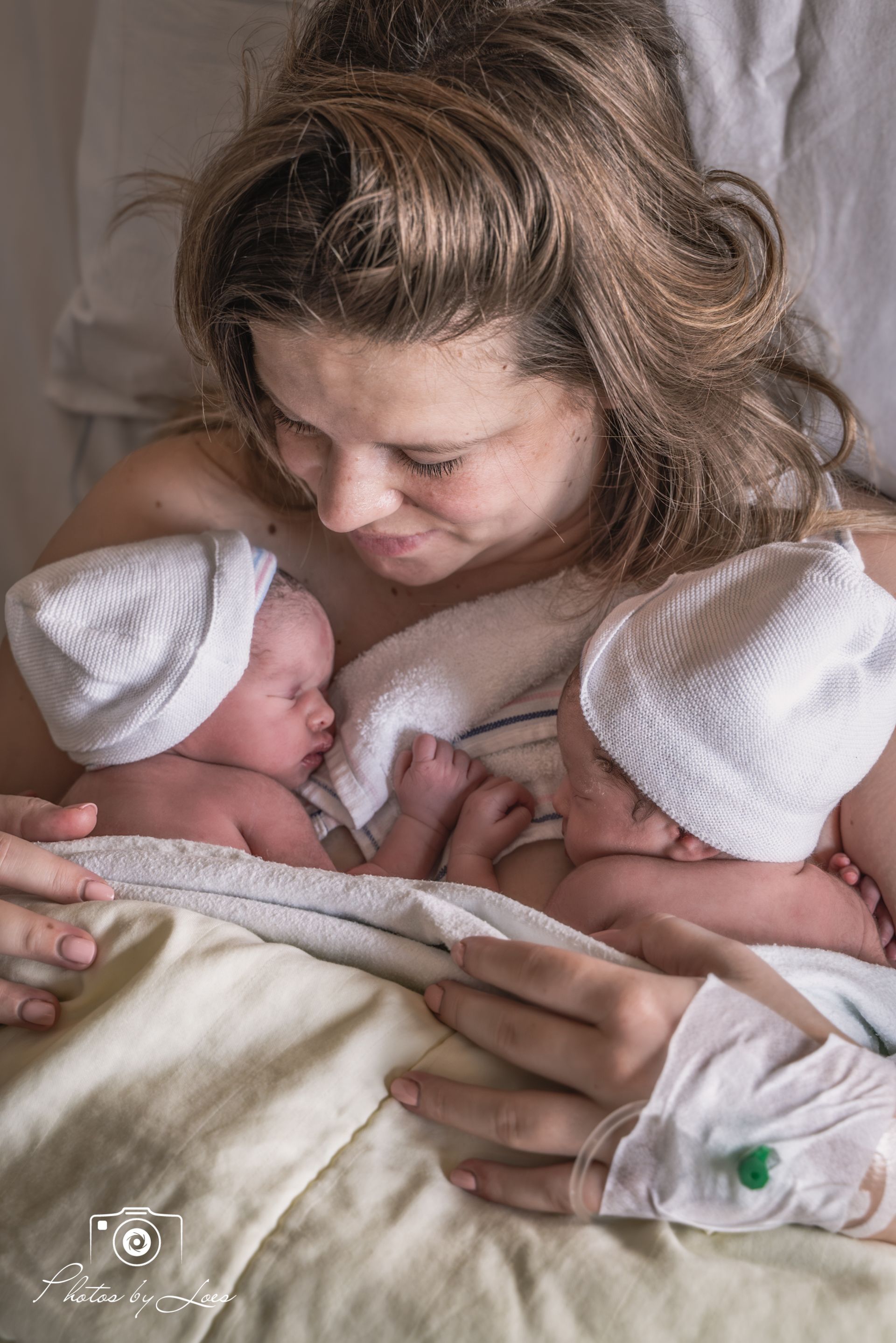 Een zwart-witfoto van een persoon die de voeten van een baby vasthoudt.