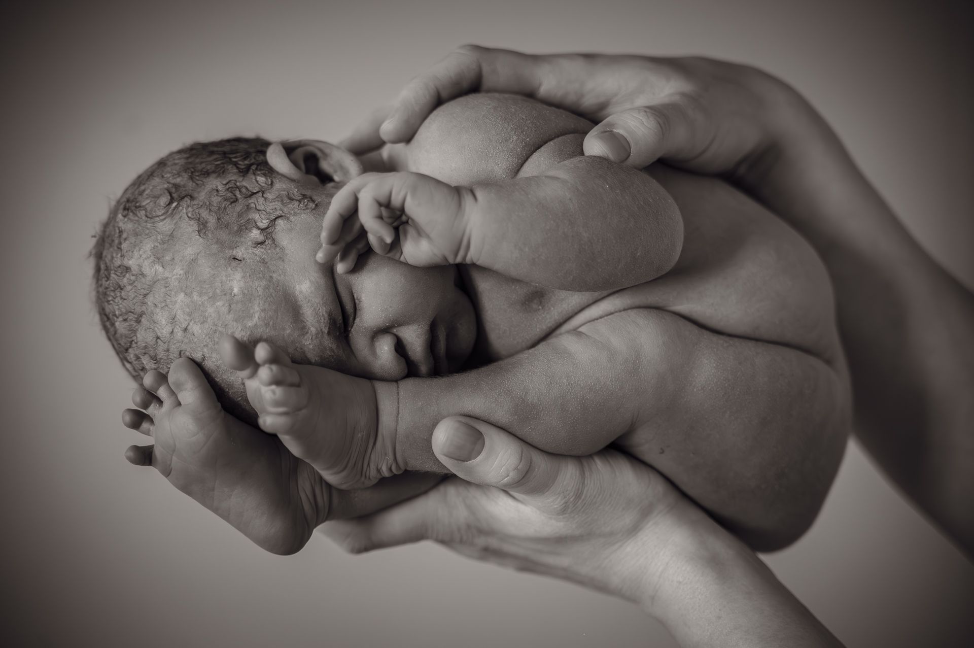 Een vrouw houdt een pasgeboren baby in haar armen.