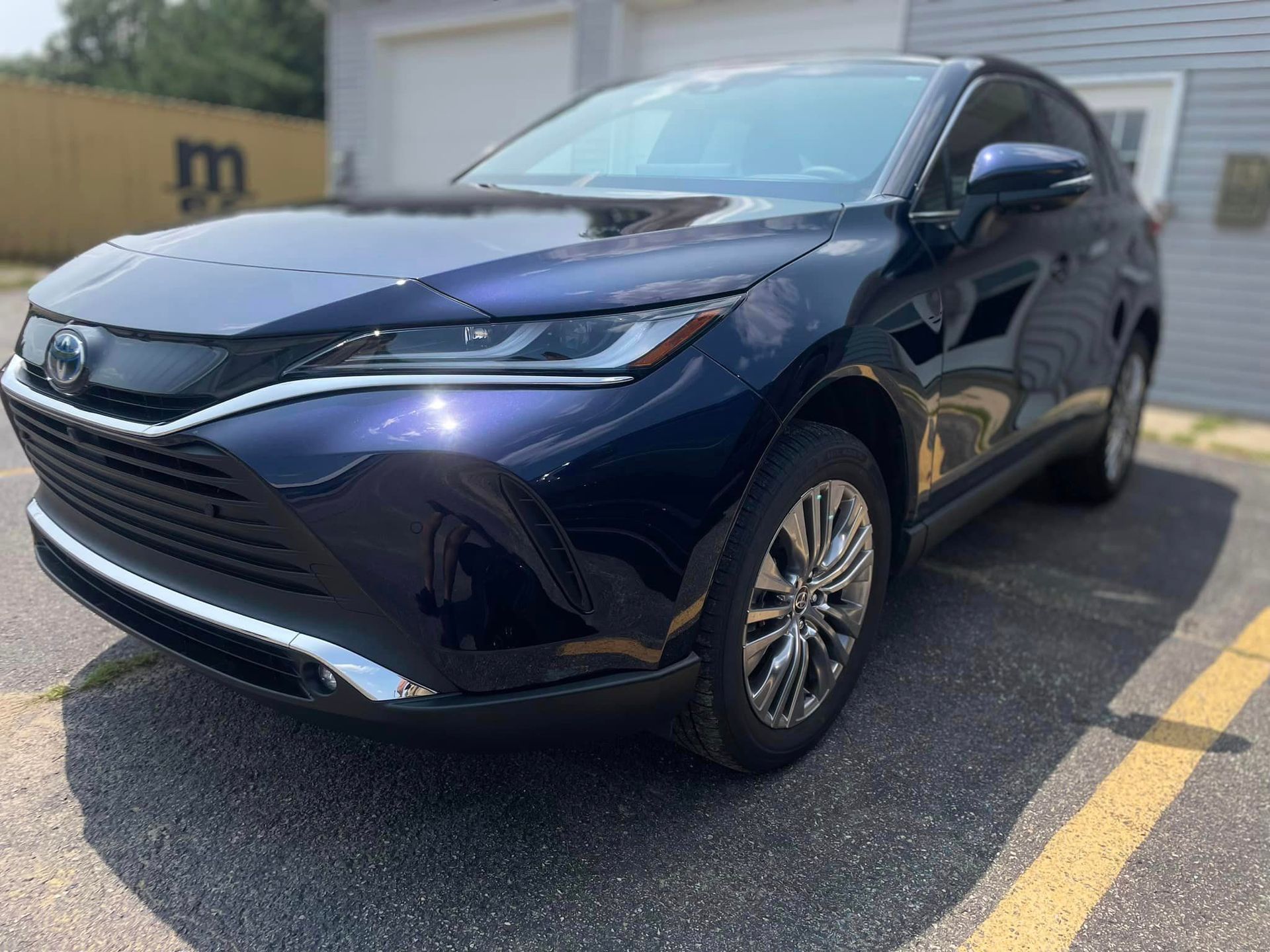 A black toyota harrier is parked in a parking lot.