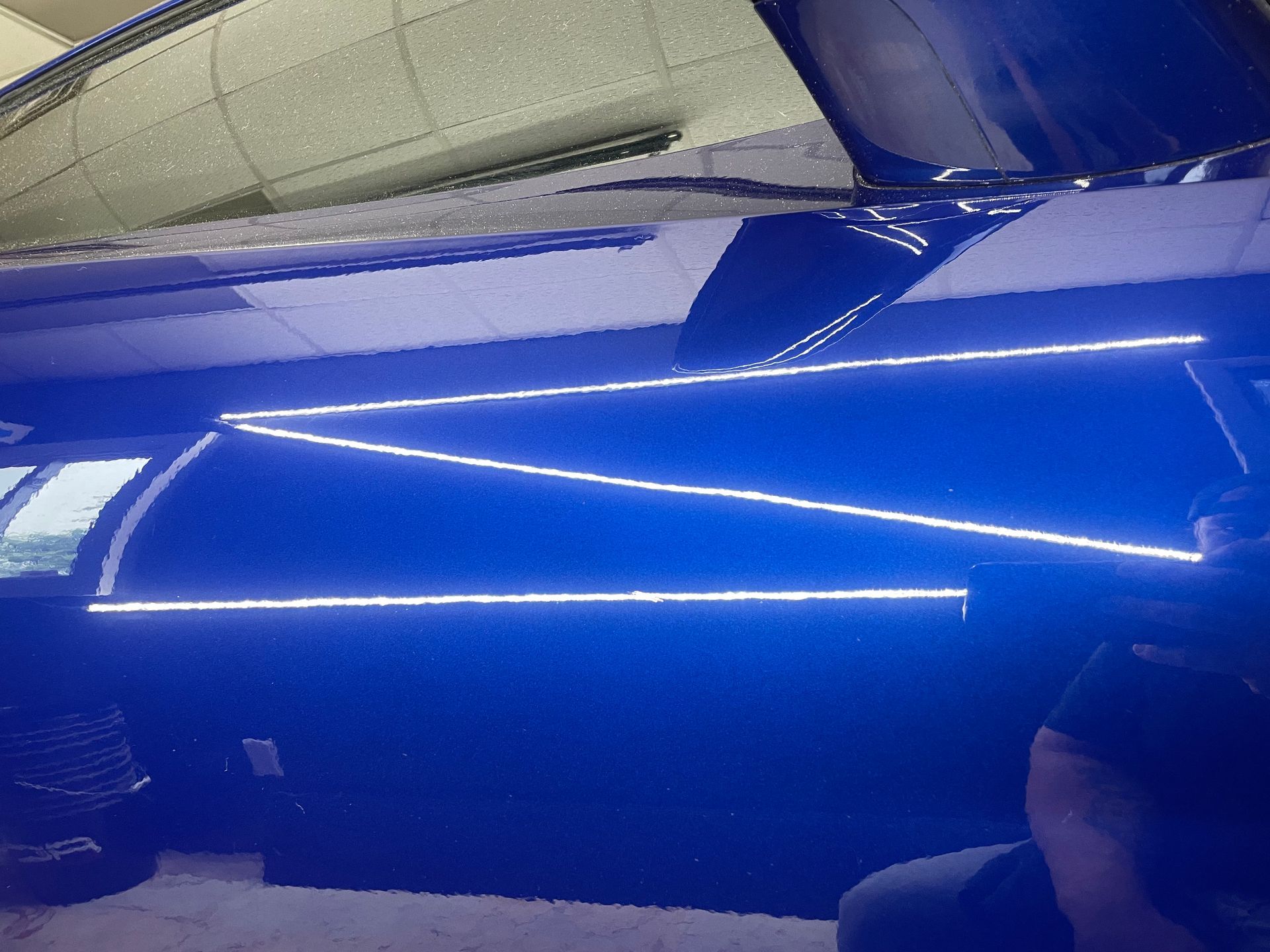 A person is taking a picture of a car with blue lights on the ceiling