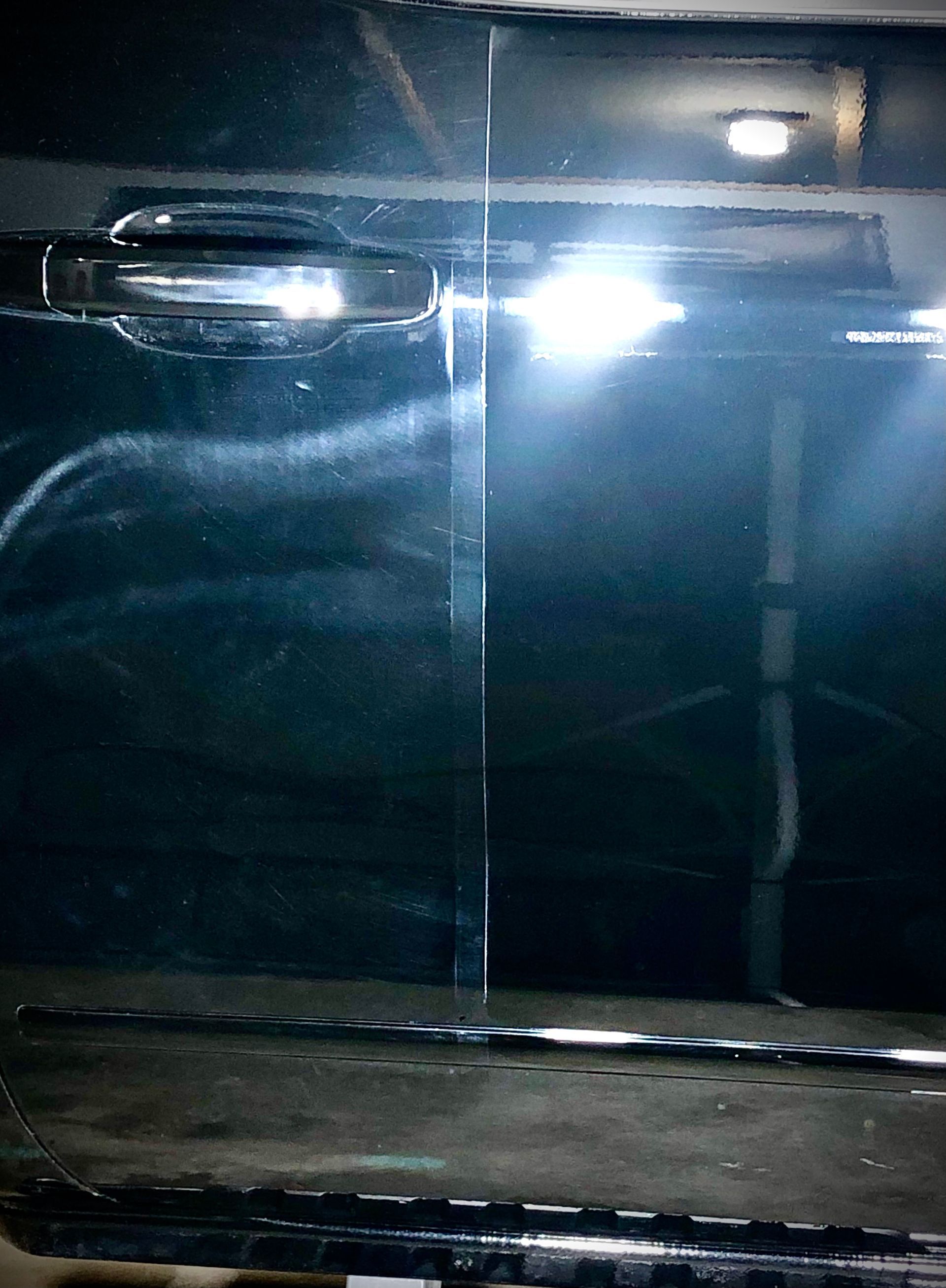 A close up of a car door with a light on it.