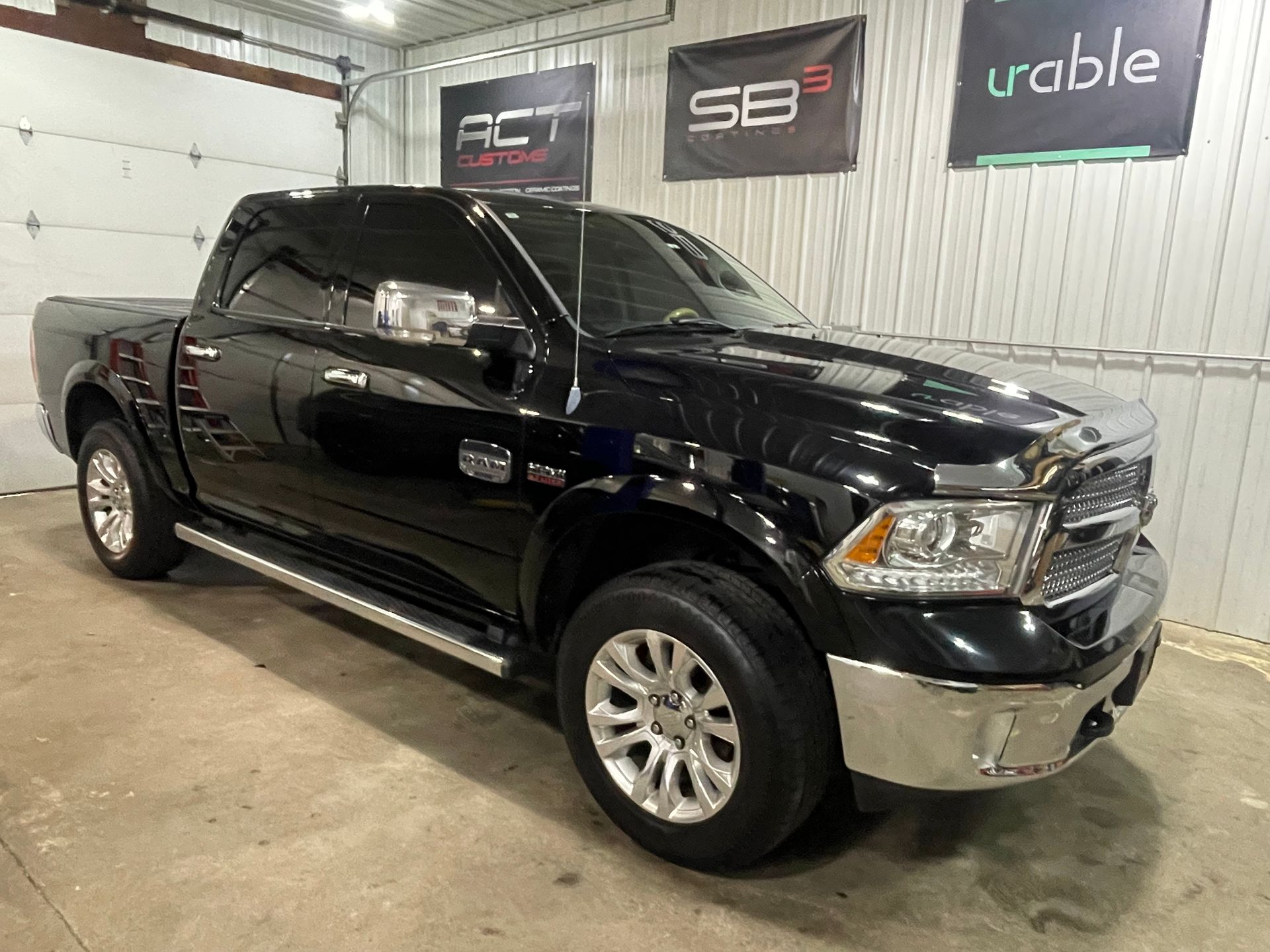 A black ram 1500 truck is parked in a garage.