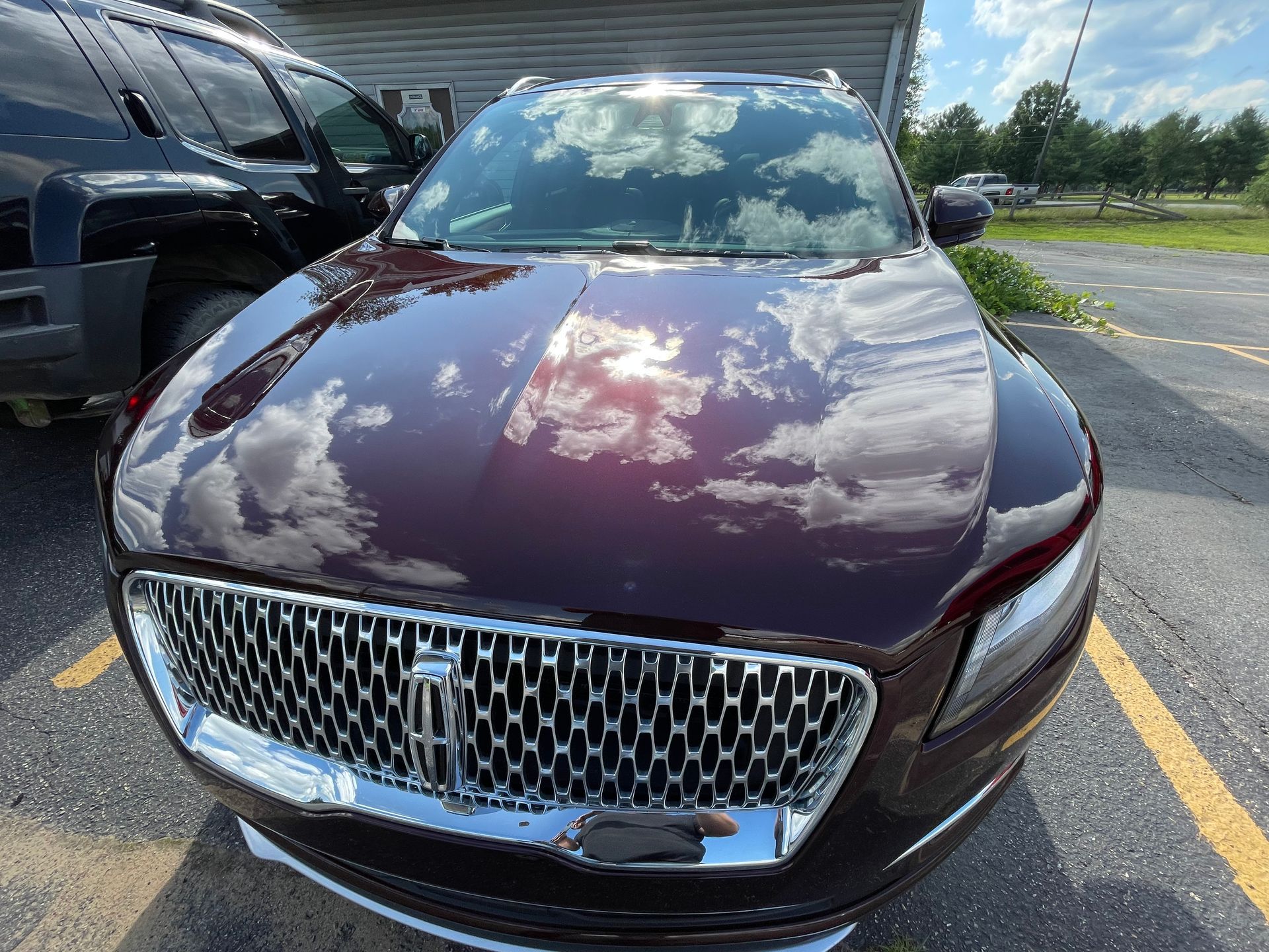 A burgundy lincoln continental is parked in a parking lot.