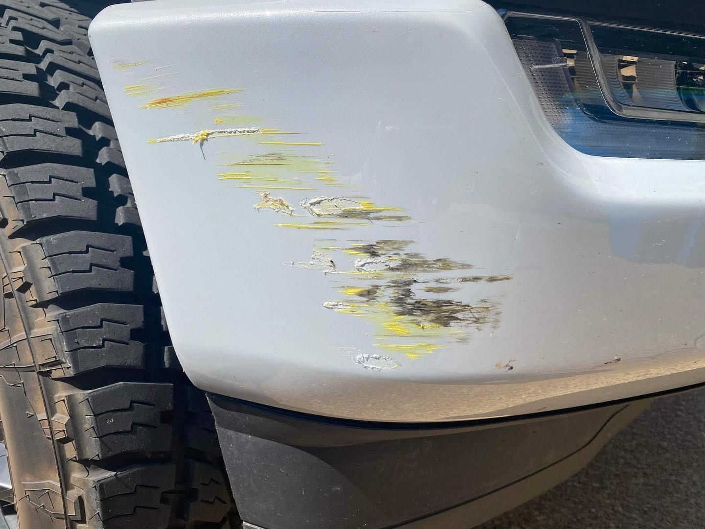 A close up of a car bumper with a yellow stain on it.