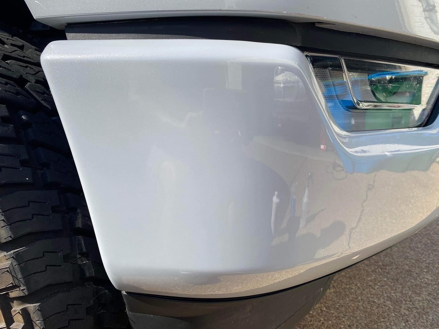 A close up of the front bumper of a white truck.