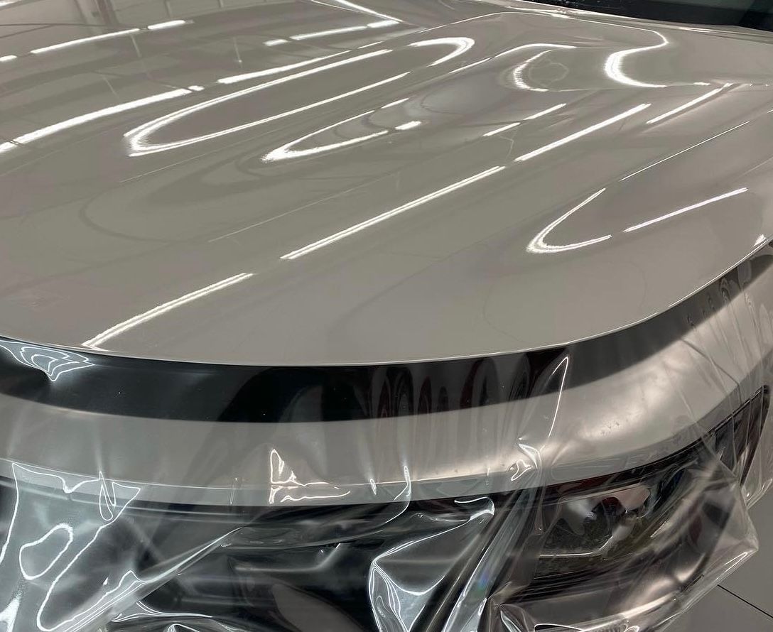 The hood of a car is wrapped in plastic.