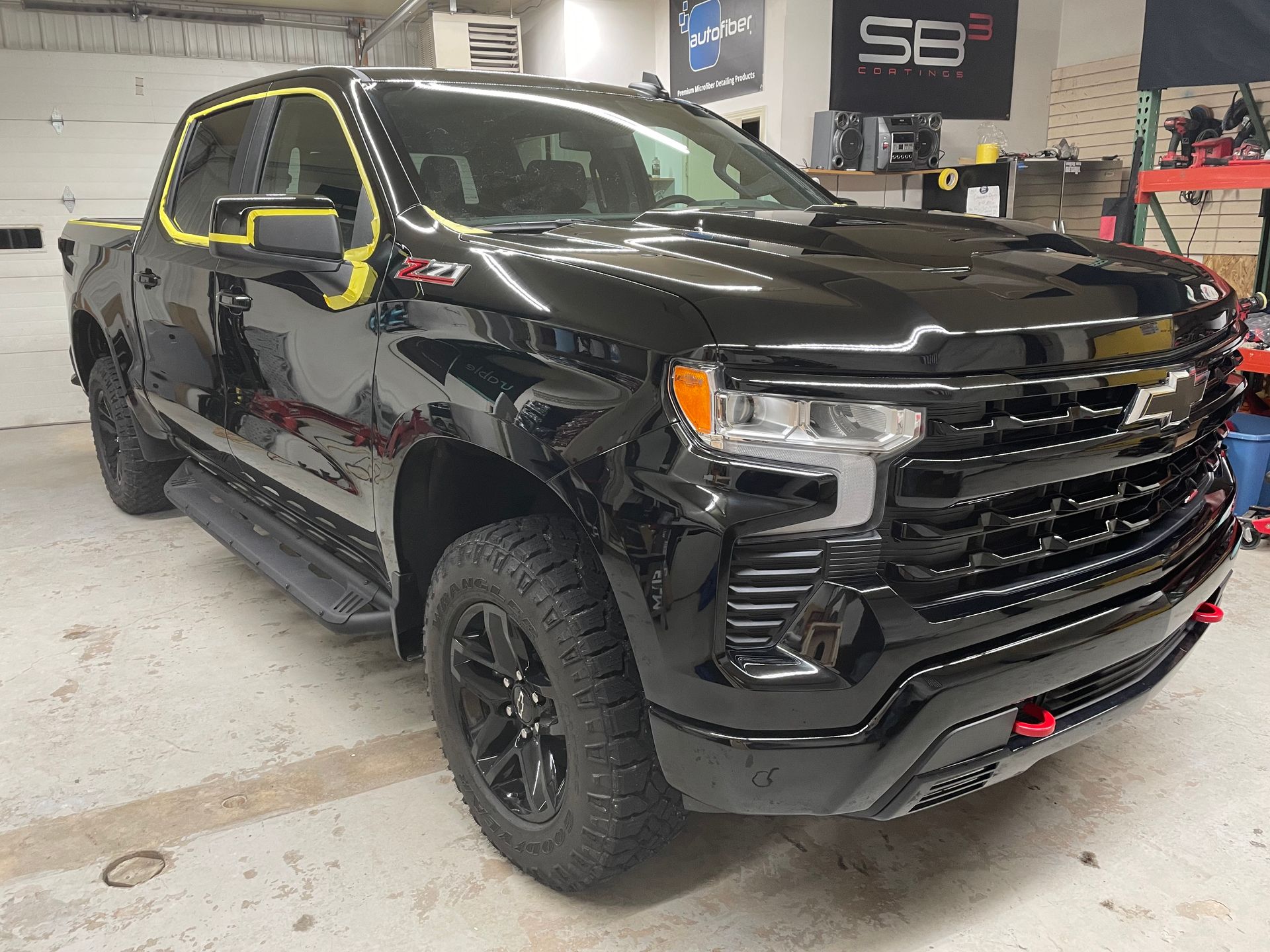 A black pickup truck is parked in a garage.