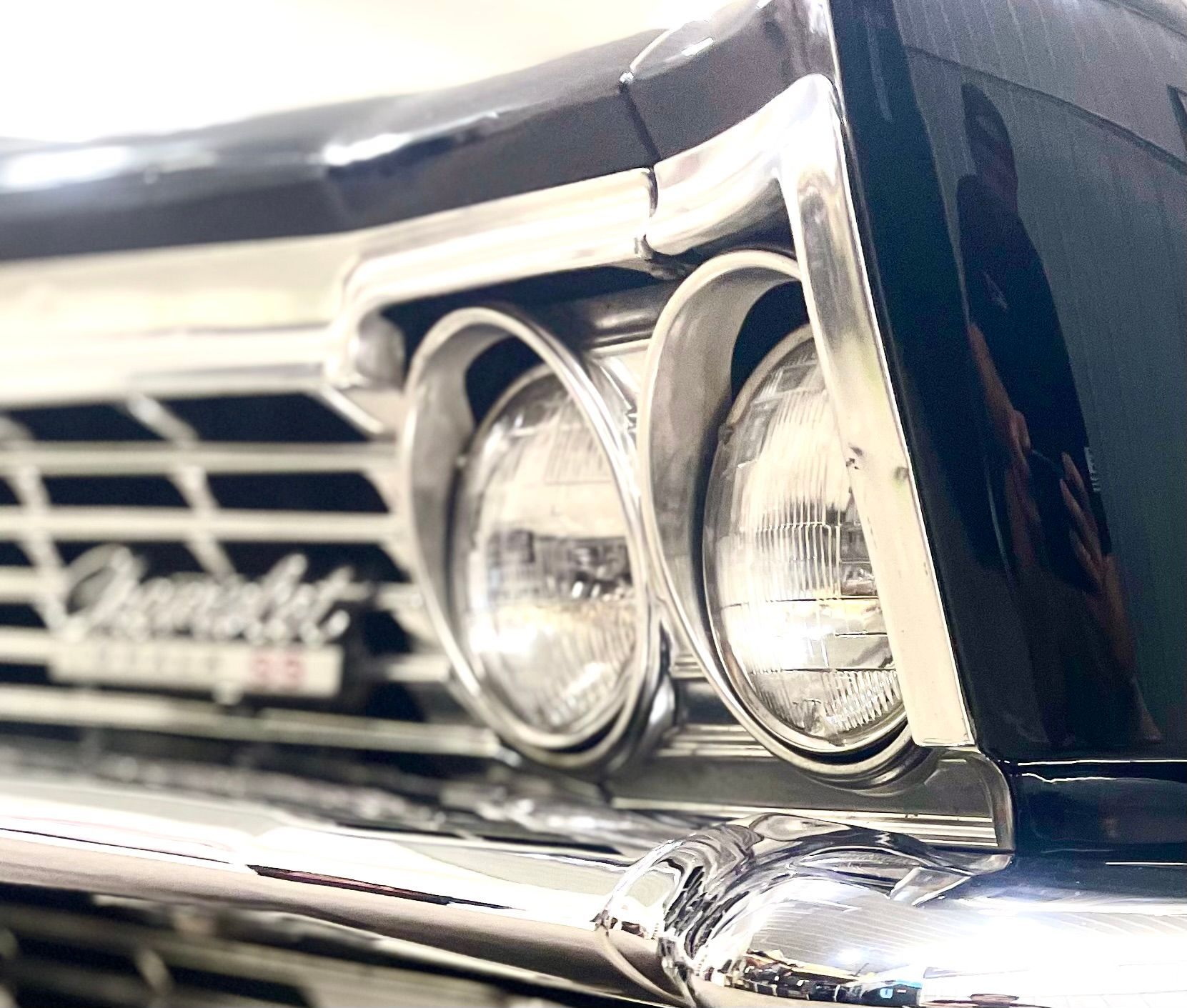 A close up of a car 's headlights and grille.